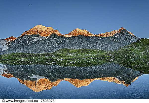 Konigspitze reflecting on surface of clear lake at dusk
