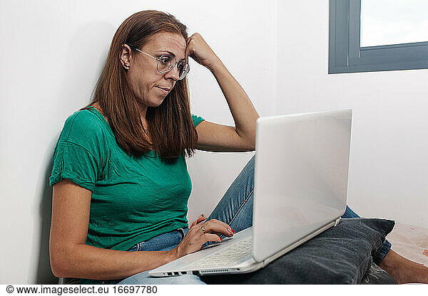 Konzentrierte Frau arbeitet online am Laptop