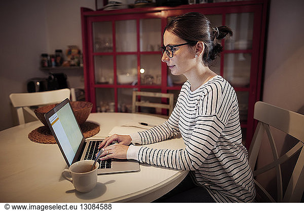 Konzentrierte Frau mit Laptop am Tisch