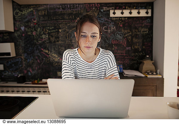 Konzentrierte Frau mit Laptop am Tisch