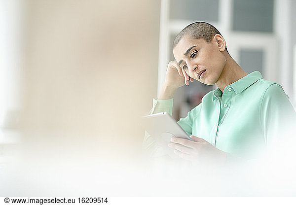 Konzentrierte Geschäftsfrau mit Tablet im Loftbüro
