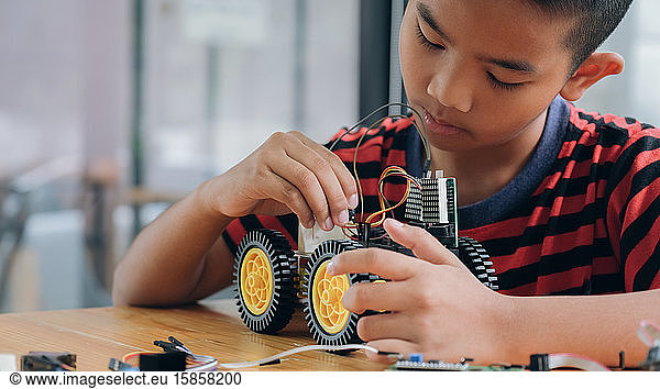 Konzentrierter Junge schafft Roboter im Labor.