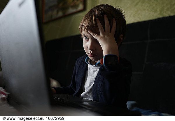 konzentriertes Kind  das am Computer sitzt