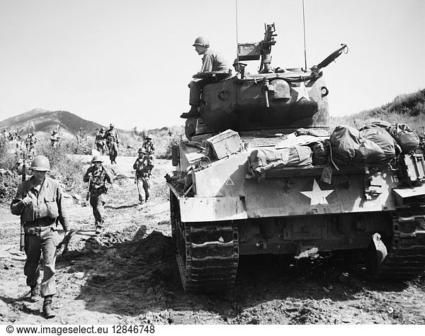 KOREAN WAR: ADVANCING. U.S. Army infantrymen  carrying rifles and shovels  and a tank advance toward Communist-held positions on the east-central Korean front  September 1951.