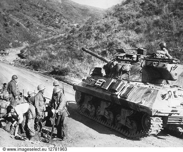 KOREAN WAR: CIVILIANS. On the west-central front in Korea an American tank passes an improvised aid station where Koreans receive first aid  October 1952.