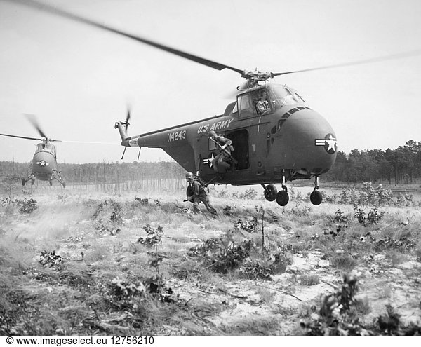 KOREAN WAR: TRAINING  1952. Paratrooper assault troops jump from a H-19 helicopter during a maneuver at Fort Bragg  North Carolina  September 1952.