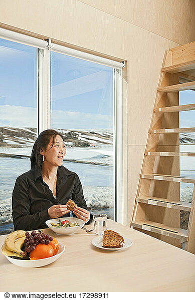 Korean woman eating salad inside country side house
