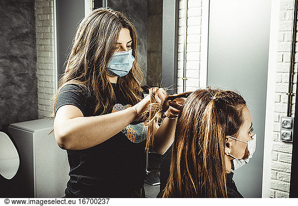 kosmetikerin und friseurin arbeiten mit maske für das covid19-virus