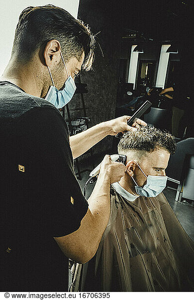 kosmetikerin und friseurin arbeiten mit maske für das covid19-virus