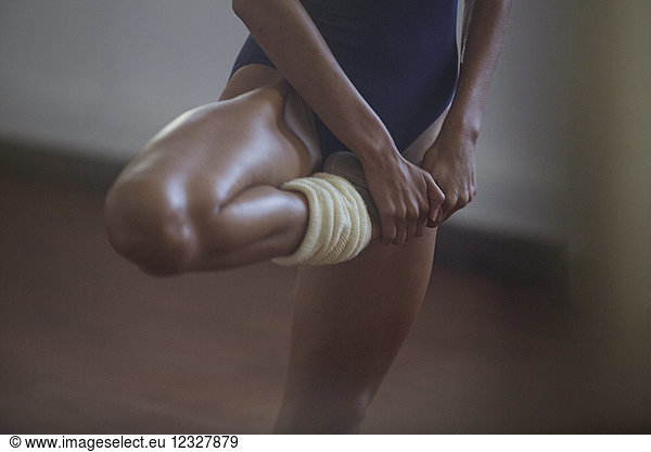 Kräftige  junge Tänzerin streckt das Bein