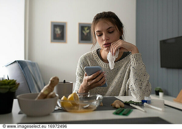 Kranke Frau benutzt Smartphone zu Hause