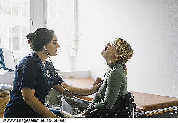 Krankenschwester bei der Untersuchung eines behinderten Patienten in einer Klinik