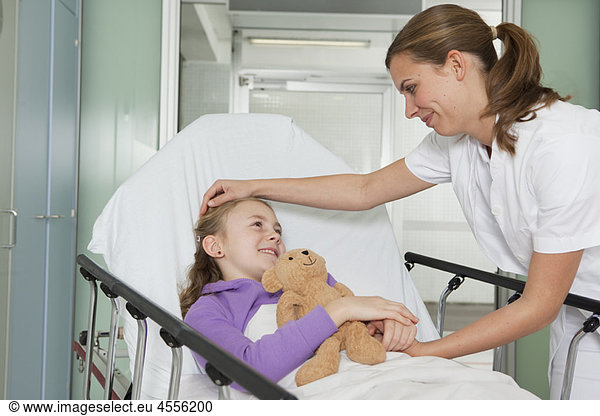 Krankenschwester streichelt krankes Mädchen