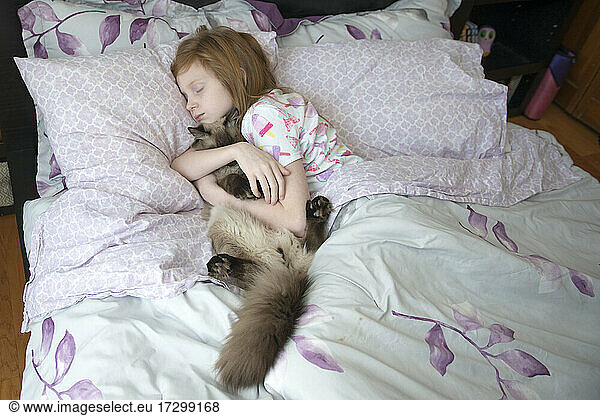 Krankes kleines Mädchen schläft im Bett mit Katze