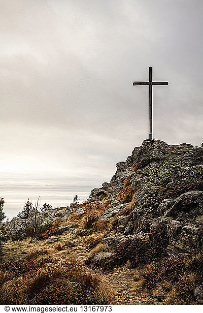 Kreuz auf felsiger Hügelspitze