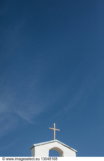 Kreuz auf Kirchturm gegen blauen Himmel
