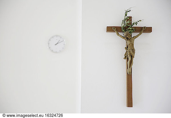 Kreuz und Uhr in einem Presbyterium