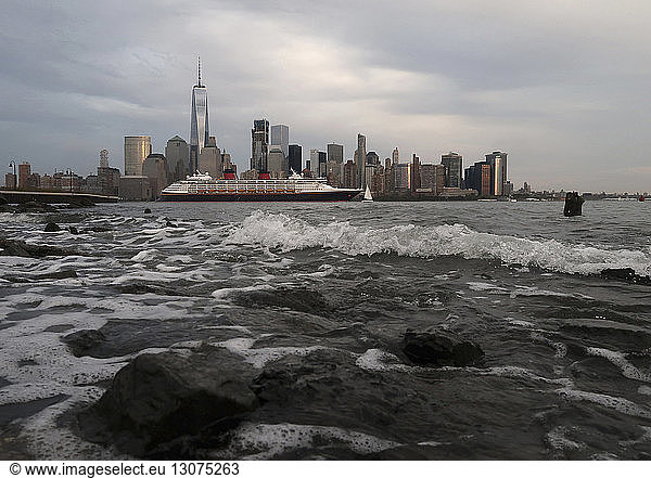 Kreuzfahrtschiff im Fluss gegen das Stadtbild in New York City