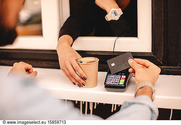 Kunde bezahlt mit Kreditkarte und kauft Kaffee am Stand