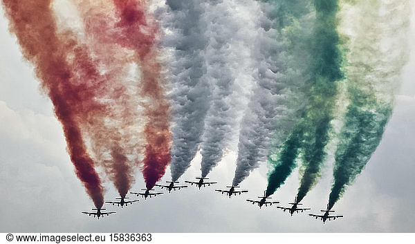 Kunstflugstaffel in enger Formation setzt farbigen Rauch in den Himmel frei