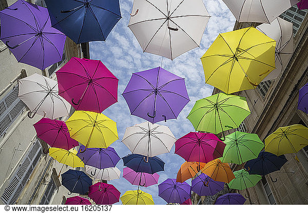 Kunstinstallation mit bunten Regenschirmen in einer Straße in Arles  Provence  Frankreich