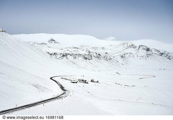 Kurvenreiche Straße durch verschneites Bergland