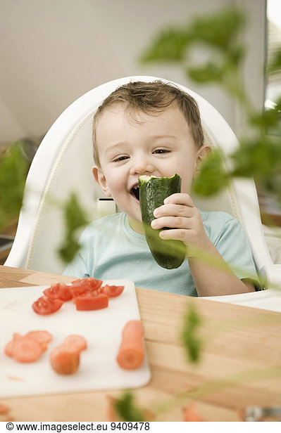 lächeln Junge - Person Küche Gurke essen essend isst