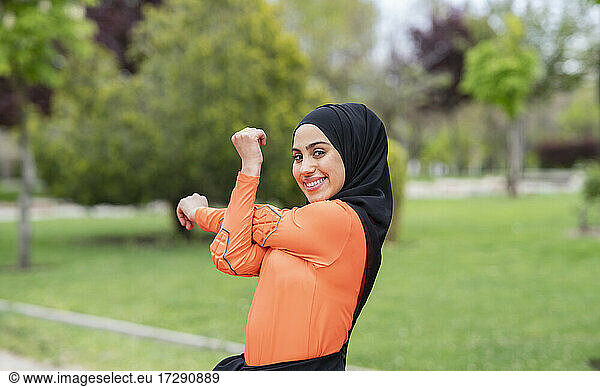 Lächelnde arabische Frau streckt sich im öffentlichen Park