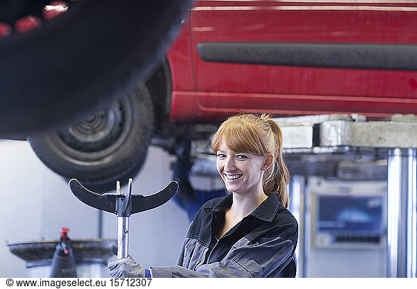 Lächelnde Automechanikerin in Reparaturwerkstatt