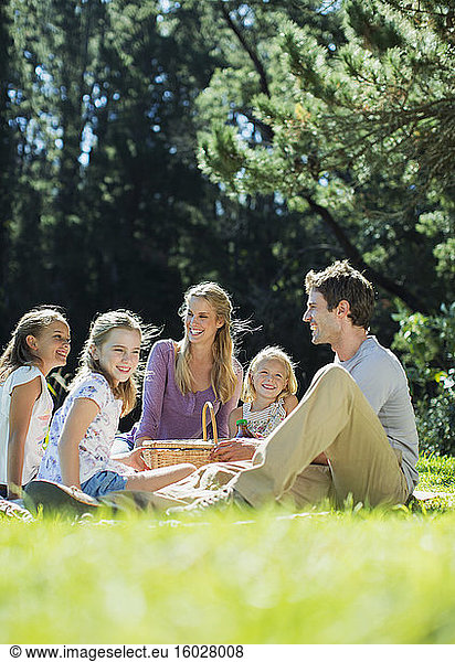 Lächelnde Familie picknickt im Gras