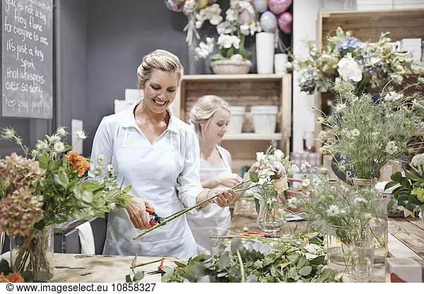 Lächelnde Floristen arrangieren Blumensträuße im Blumenladen