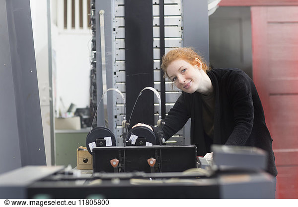Lächelnde Frau an einer Druckmaschine