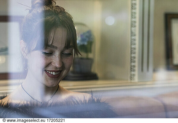 Lächelnde Frau hinter Fensterscheibe