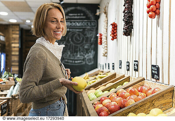 Lächelnde Frau kauft Obst im Supermarkt