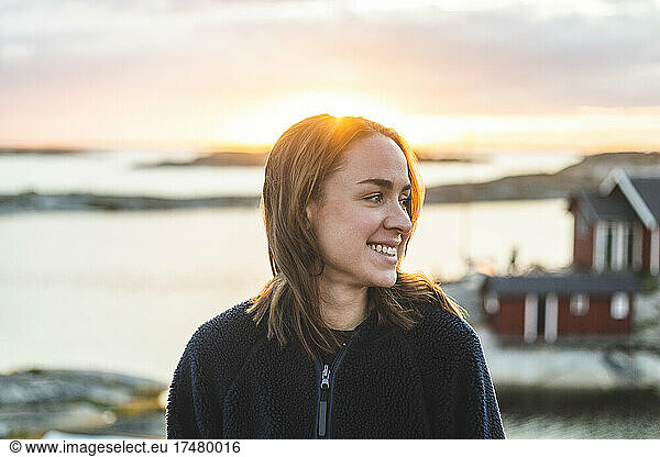 Lächelnde Frau mit Blick auf eine Insel im Sommerurlaub