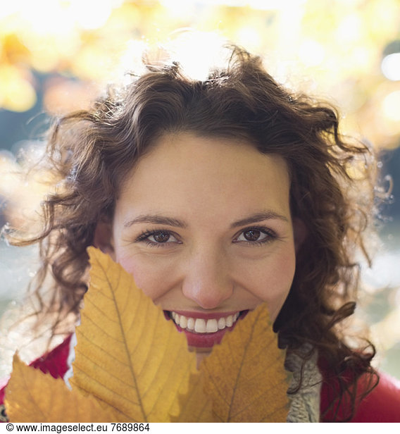 Lächelnde Frau mit Herbstblatt