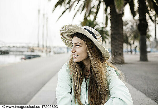 Lächelnde Frau mit Hut im Freien