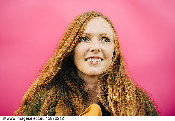 Lächelnde Frau mittleren Alters vor rosa Hintergrund