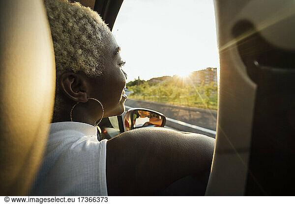 Lächelnde Frau schaut durch ein Autofenster