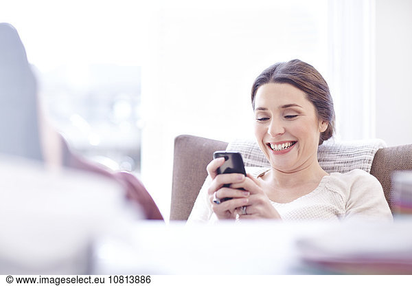 Lächelnde Frau SMS mit Handy