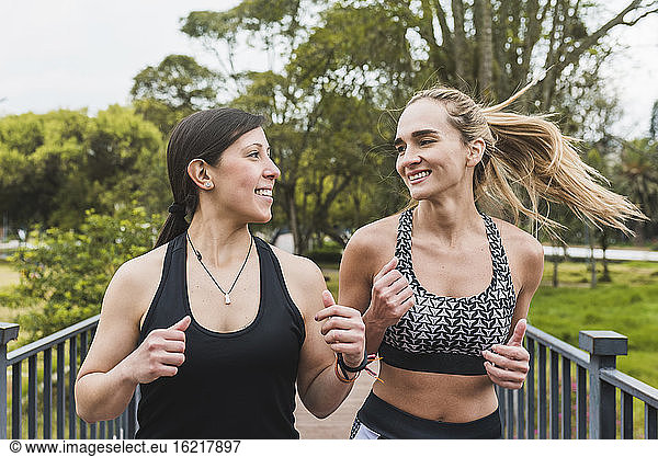 Lächelnde Freundinnen joggen im Park