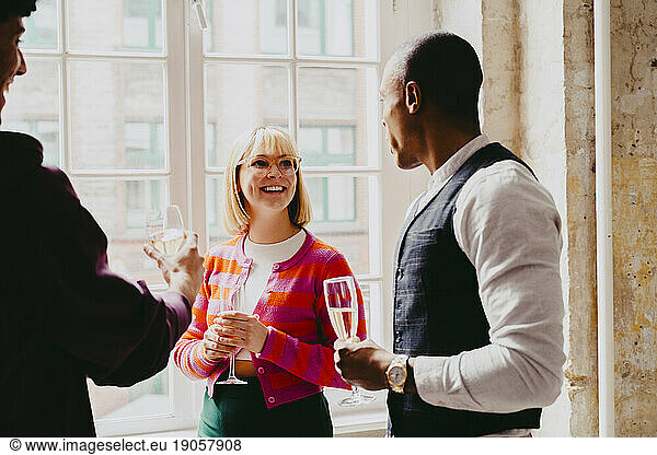Lächelnde Geschäftsfrau bei einem Drink mit einem männlichen Kollegen während einer Veranstaltung im Kongresszentrum