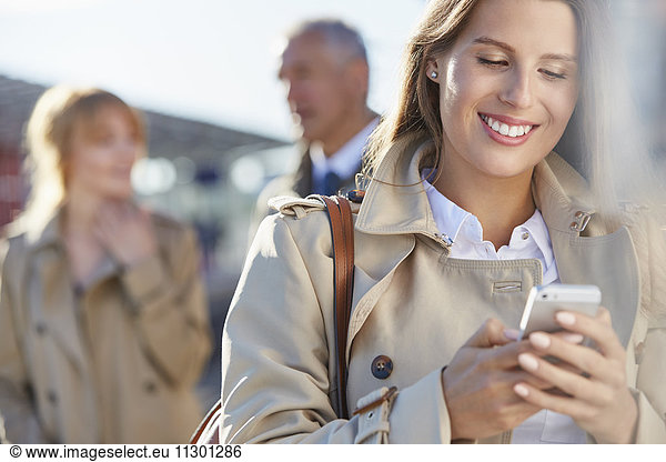 Lächelnde Geschäftsfrau SMS mit Handy