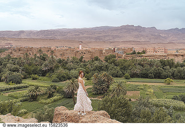 Lächelnde junge Frau auf einem Felsen stehend  Ouarzazate  Marokko