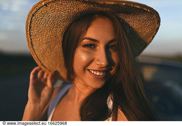 Lächelnde junge Frau mit Hut