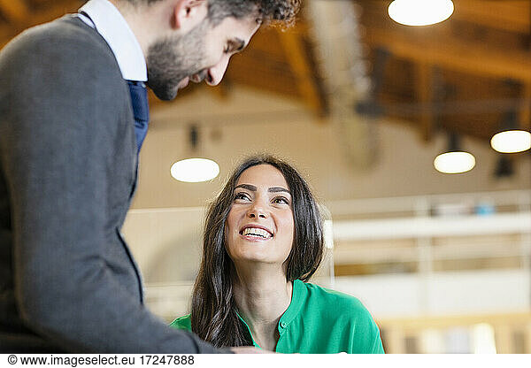 Lächelnde männliche und weibliche Fachkräfte  die sich im Büro ansehen