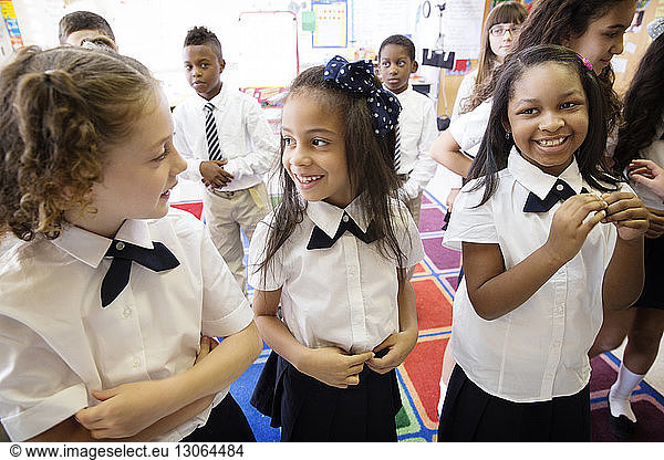 Lächelnde Schüler stehen im Klassenzimmer