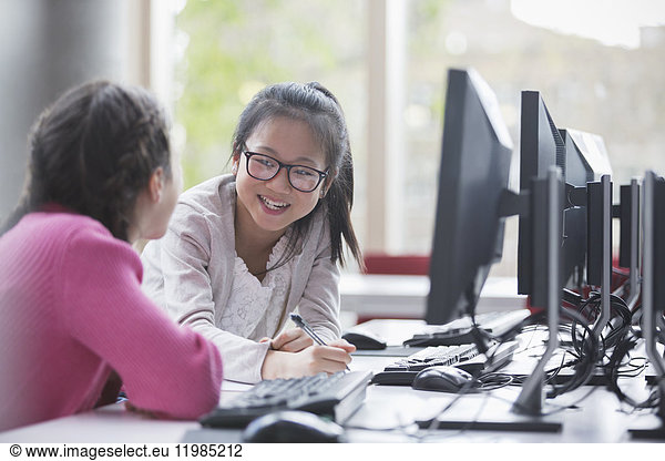 Lächelnde Schülerinnen forschen am Computer im Laborunterricht
