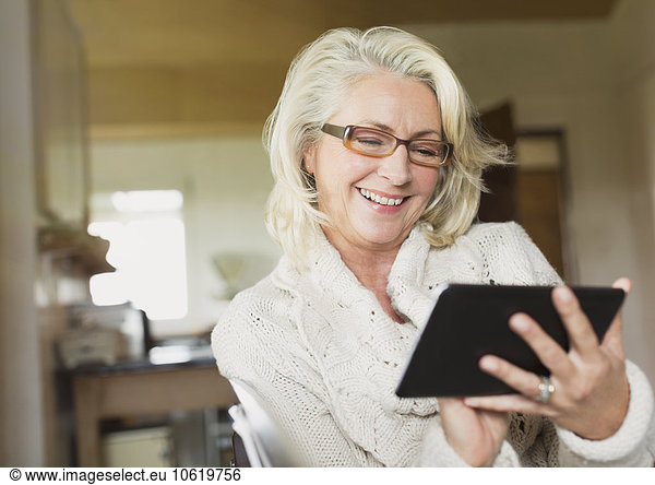 Lächelnde Seniorin mit digitalem Tablett