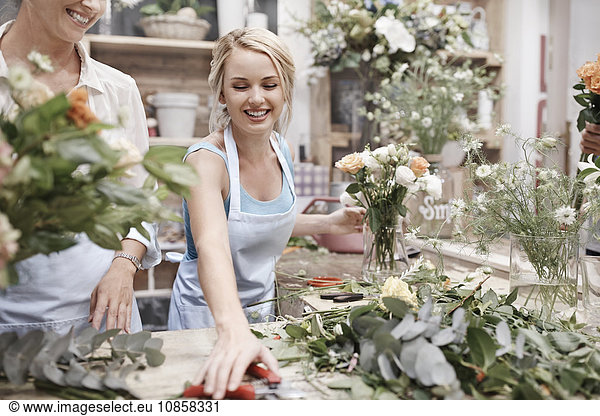 Lächelnder Florist arrangiert Blumenstrauß im Blumenladen